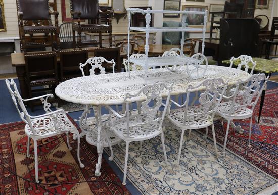 A large painted garden table with eight elbow chairs and a drinks trolley W. of table 235cm